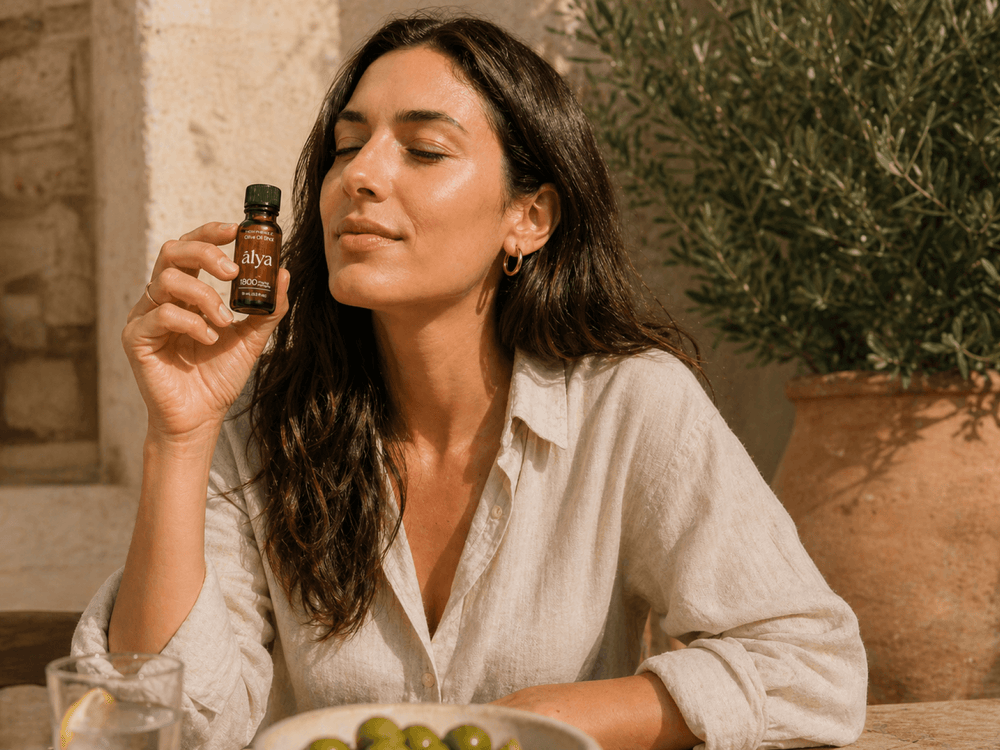 A woman smelling an Alya olive oil shot